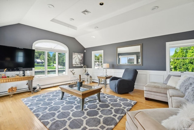 living room with a baseboard radiator, light hardwood / wood-style floors, and lofted ceiling