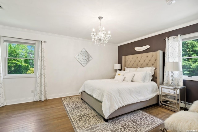 bedroom featuring a chandelier, crown molding, and wood-type flooring