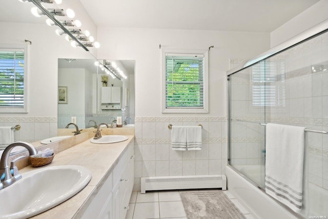 bathroom with tile patterned floors, combined bath / shower with glass door, tile walls, and a baseboard heating unit