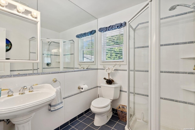 bathroom with tile patterned flooring, toilet, an enclosed shower, and sink