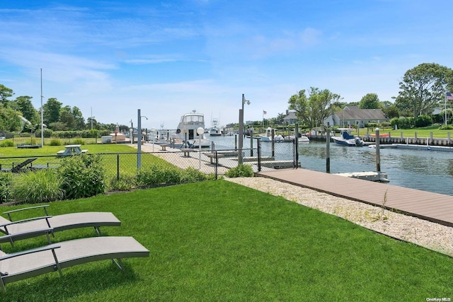 view of home's community featuring a water view, a dock, and a lawn