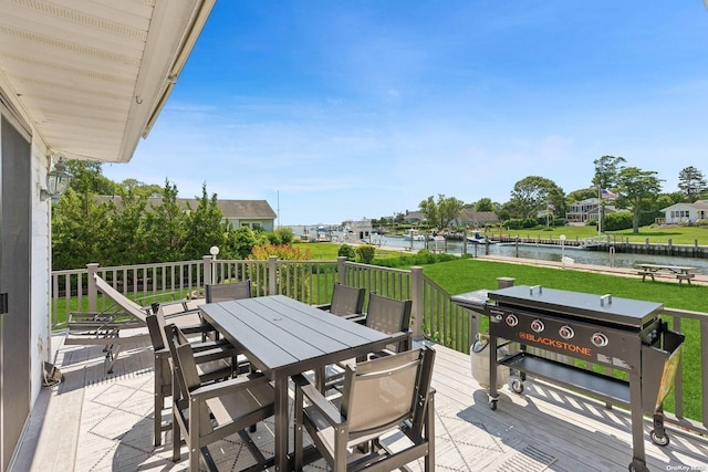 wooden terrace featuring a water view and a lawn