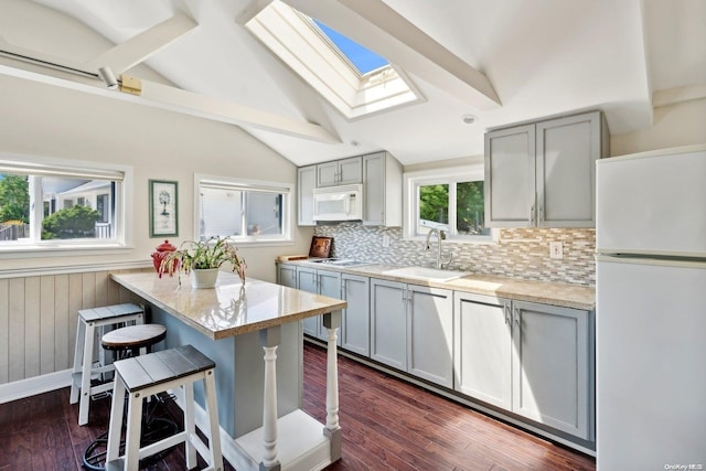 14C Penny Ln, Hampton Bays, NY 11946 - kitchen featuring white appliances, a sink, a skylight, and gray cabinetry