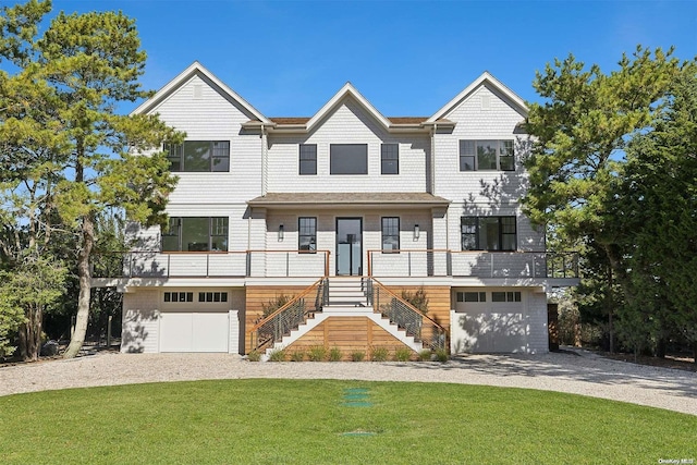 view of front of house with a porch, a garage, and a front lawn