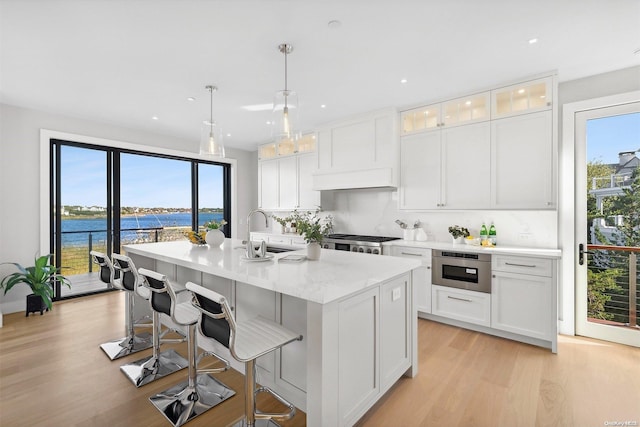 kitchen with white cabinets, plenty of natural light, a water view, and appliances with stainless steel finishes