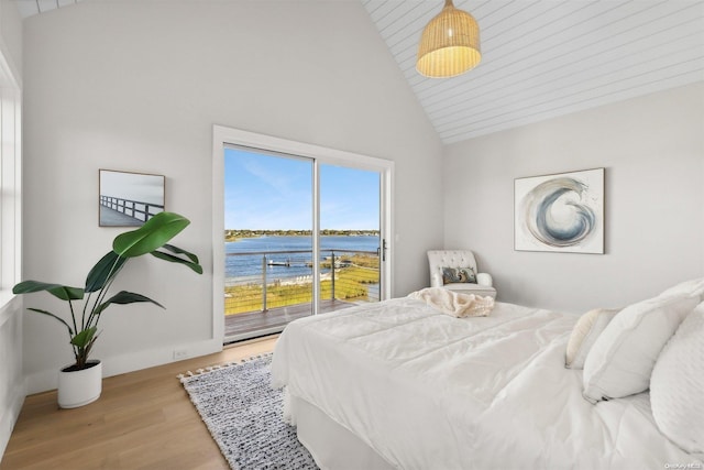 bedroom with access to exterior, light hardwood / wood-style flooring, a water view, and high vaulted ceiling