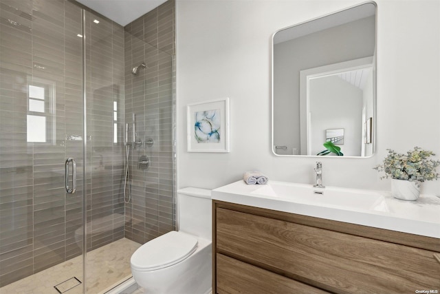 bathroom with vanity, toilet, and a shower with door