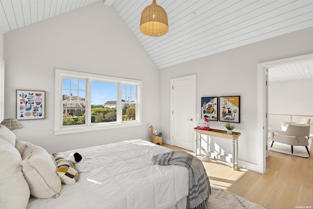 bedroom featuring light hardwood / wood-style floors, high vaulted ceiling, and wood ceiling