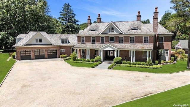 colonial inspired home featuring a garage and a front yard