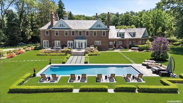 back of property with outdoor lounge area, a yard, and a patio