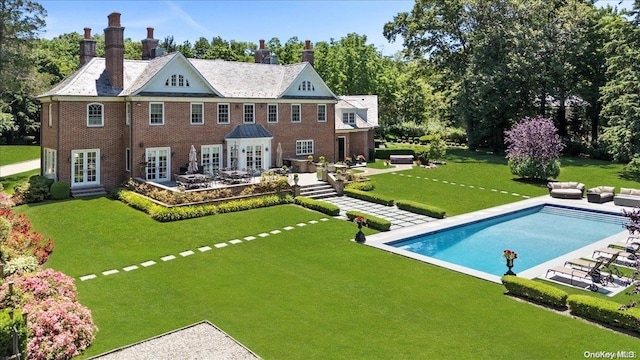 back of house with a lawn, a patio area, and french doors