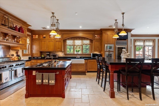 kitchen with decorative light fixtures, a kitchen island, and a wealth of natural light