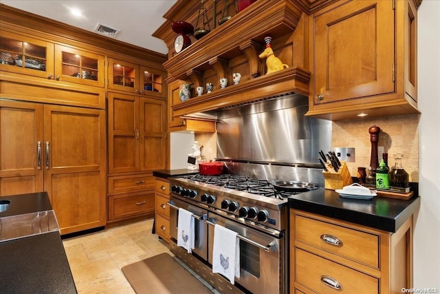 kitchen featuring decorative backsplash and range with two ovens