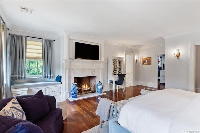 bedroom with a high end fireplace, dark hardwood / wood-style floors, and ornamental molding