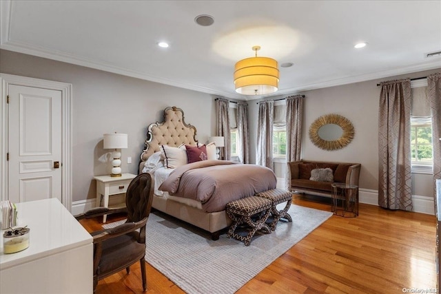 bedroom with hardwood / wood-style flooring, ornamental molding, and multiple windows