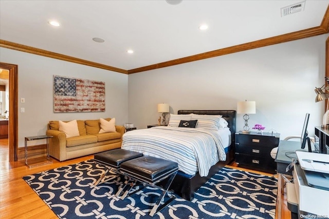 bedroom with crown molding and hardwood / wood-style floors