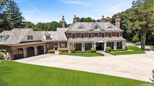 colonial house featuring a garage and a front lawn