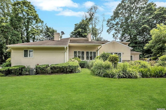 back of property with a lawn and central air condition unit