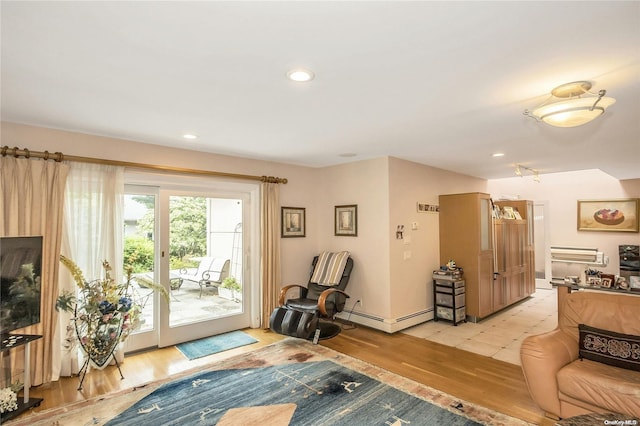 living room featuring light hardwood / wood-style floors, french doors, and a baseboard heating unit