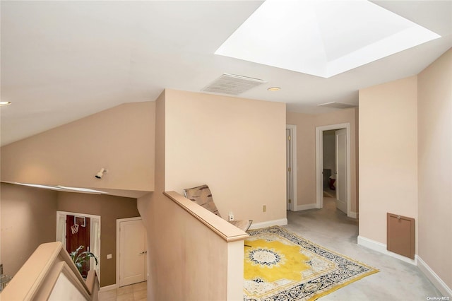 hall with a skylight and light colored carpet