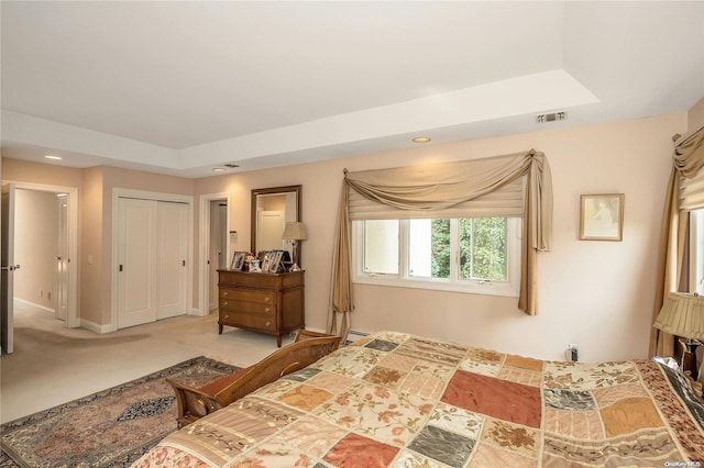 carpeted bedroom with a baseboard radiator, a raised ceiling, and a closet