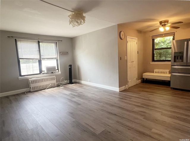 unfurnished room featuring hardwood / wood-style floors, ceiling fan, and a wall mounted air conditioner