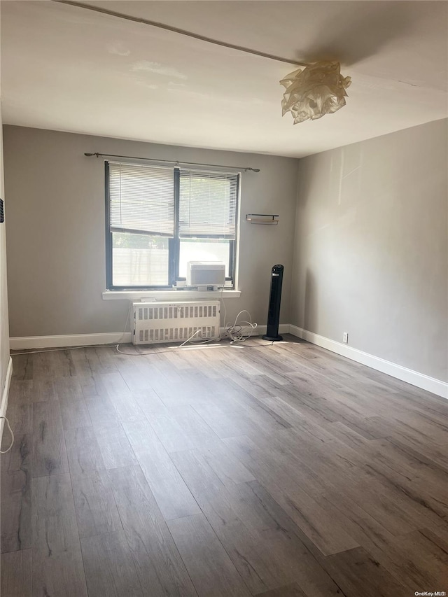 spare room with radiator and wood-type flooring