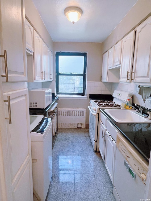 kitchen with white appliances, radiator, sink, decorative backsplash, and washer / clothes dryer