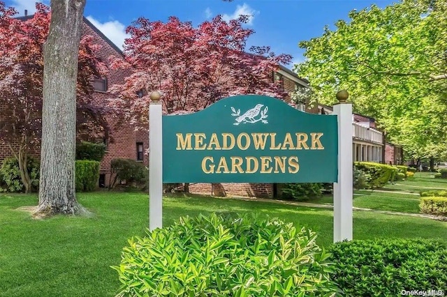 community sign featuring a lawn