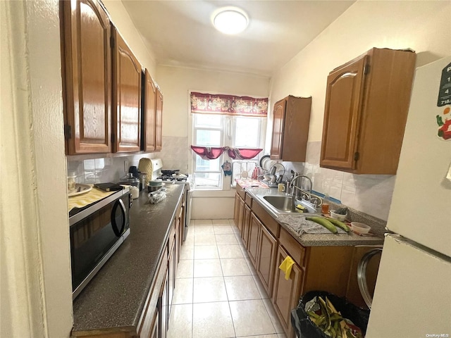 kitchen with decorative backsplash, sink, light tile patterned flooring, and appliances with stainless steel finishes