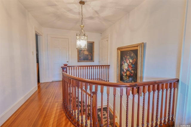 hallway featuring hardwood / wood-style floors and an inviting chandelier