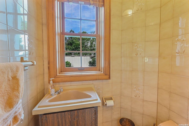 bathroom with vanity and tile walls