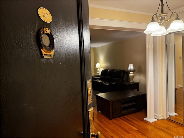 interior details with hardwood / wood-style floors, a notable chandelier, and crown molding