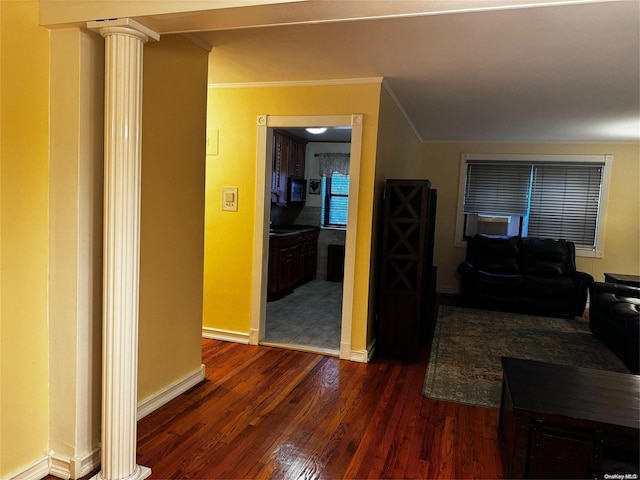 corridor featuring dark hardwood / wood-style flooring, decorative columns, and ornamental molding