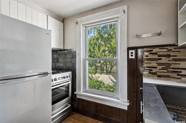 kitchen featuring white cabinetry, a wealth of natural light, dark hardwood / wood-style flooring, and stainless steel appliances