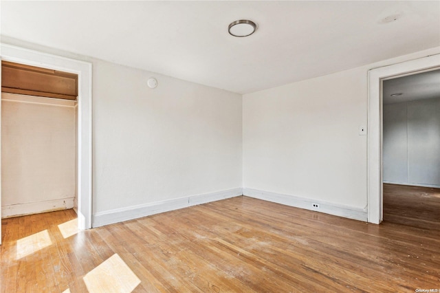 unfurnished bedroom with a closet and hardwood / wood-style flooring