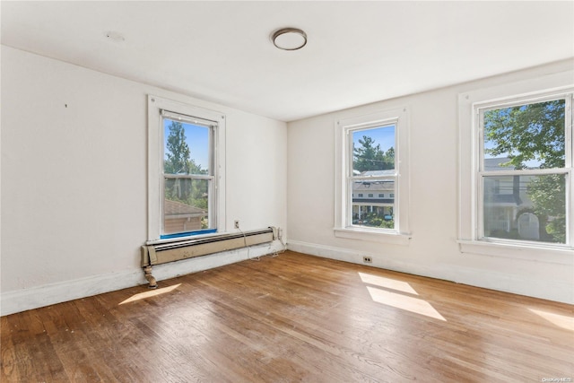 spare room with wood-type flooring and baseboard heating