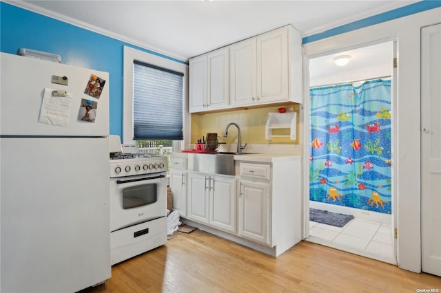 kitchen featuring sink, backsplash, white appliances, white cabinets, and light wood-type flooring