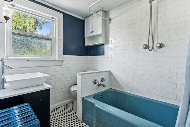 bathroom featuring crown molding, vanity, tile walls, and toilet