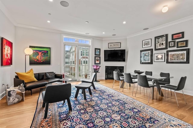 living room with crown molding and light hardwood / wood-style flooring