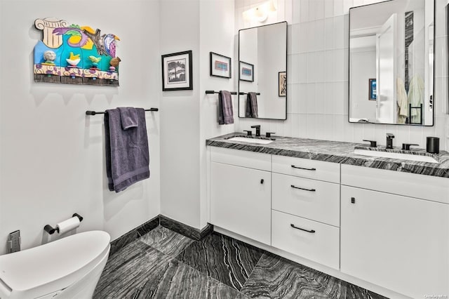 bathroom with backsplash, vanity, and toilet