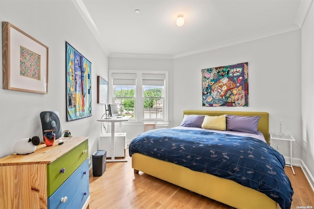 bedroom featuring crown molding and light hardwood / wood-style flooring