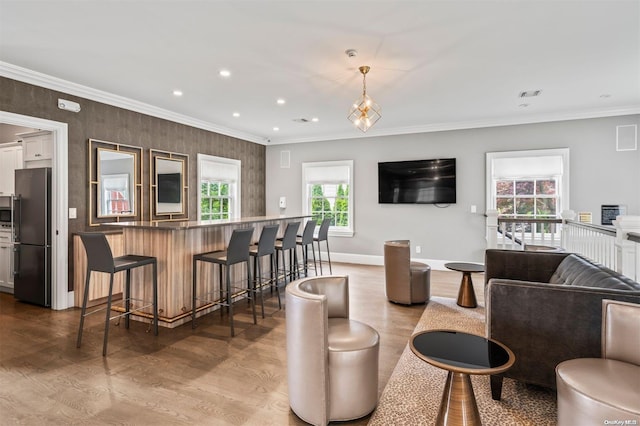 living room featuring crown molding, plenty of natural light, and light hardwood / wood-style floors