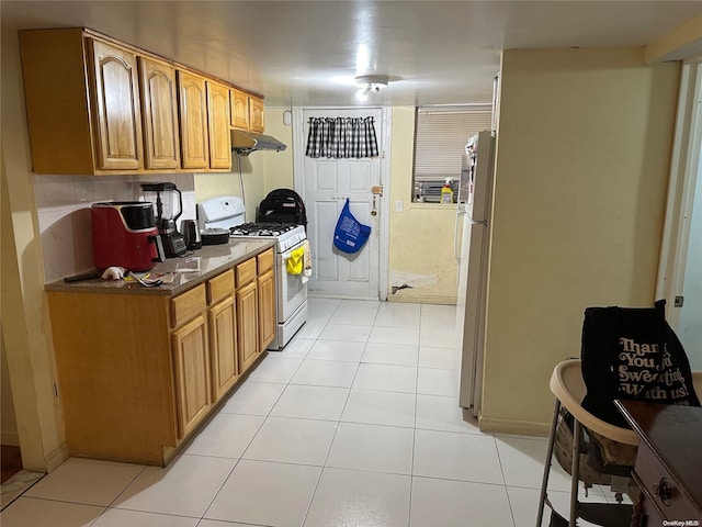 kitchen with white appliances and light tile patterned flooring