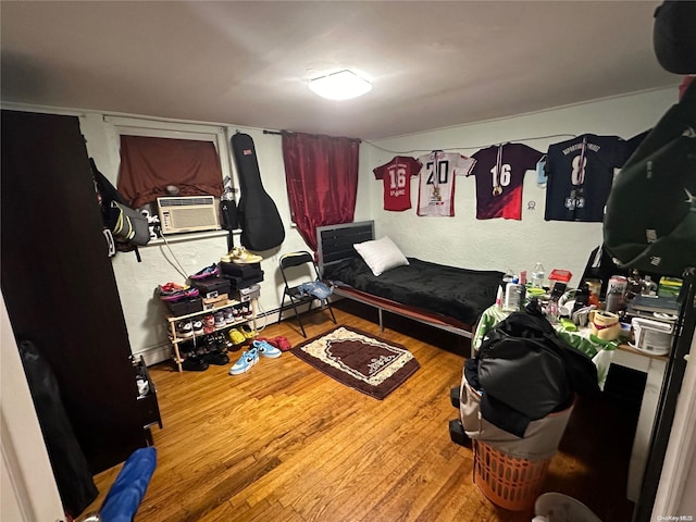 bedroom with cooling unit and wood-type flooring