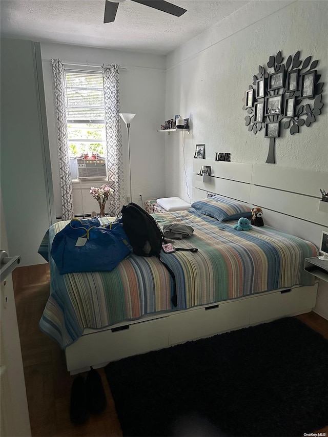 bedroom with a textured ceiling, ceiling fan, and cooling unit