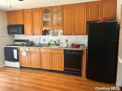 kitchen with sink, black appliances, and light wood-type flooring