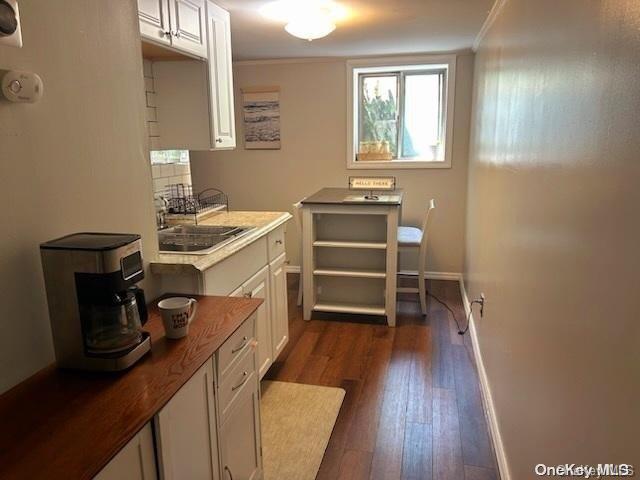 office with sink, dark wood-type flooring, and ornamental molding