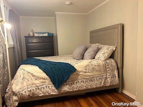 bedroom featuring crown molding and dark hardwood / wood-style floors