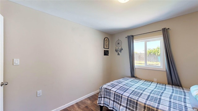 bedroom with dark hardwood / wood-style floors